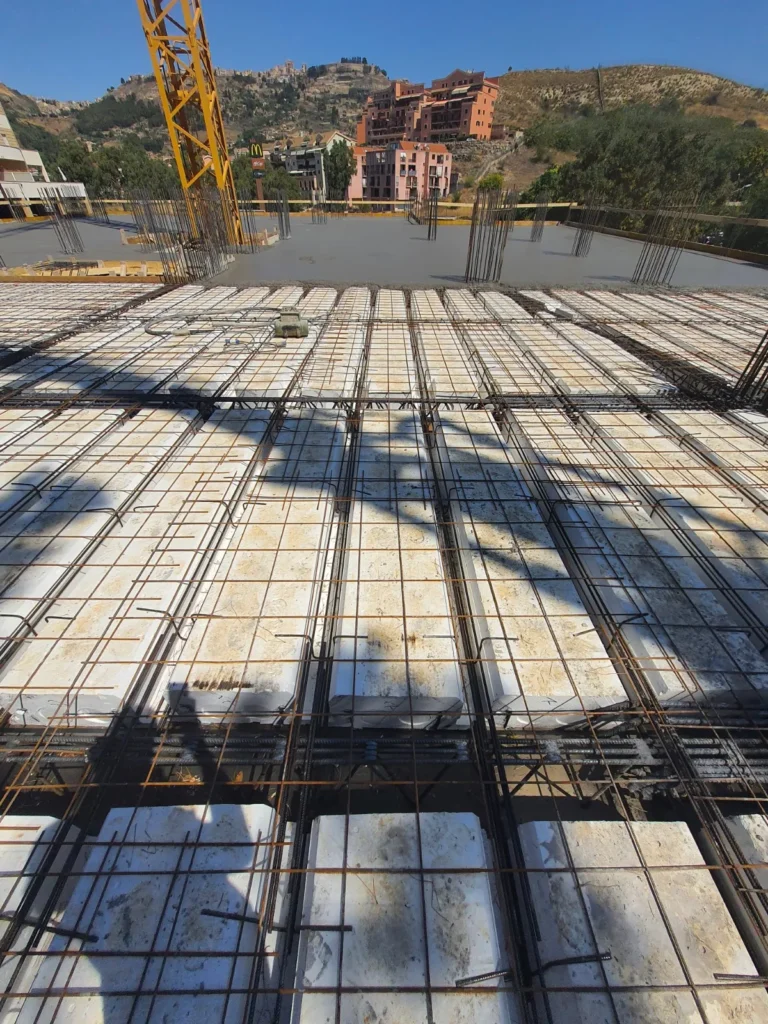 Armatura del solaio con gru di cantiere, sullo sfondo Enna