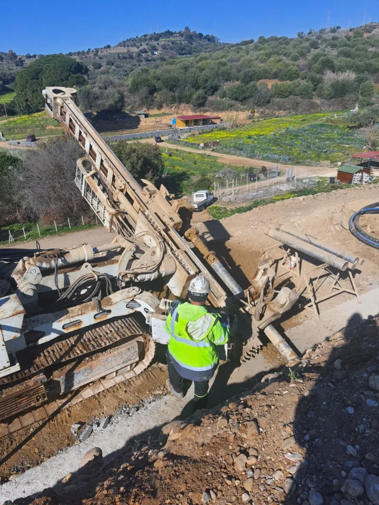 Perforatrice cingolata al lavoro con operatore in cantiere